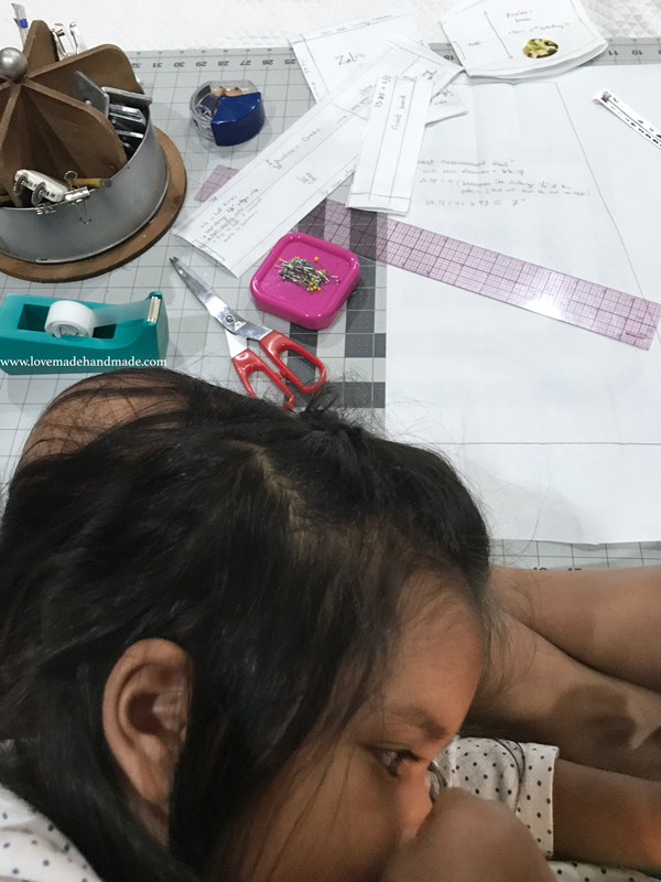 Toddler Nursing while mom drafts a sewing pattern - Lovemade Handmade